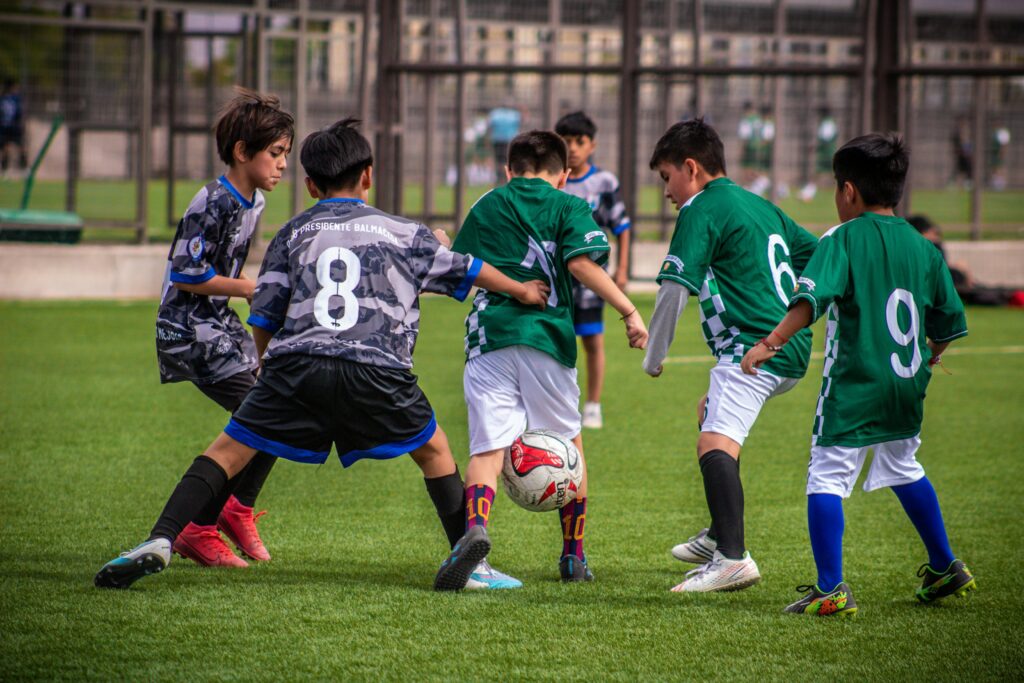 Young soccer players engaging in a dynamic football training session on a Chilean field.
