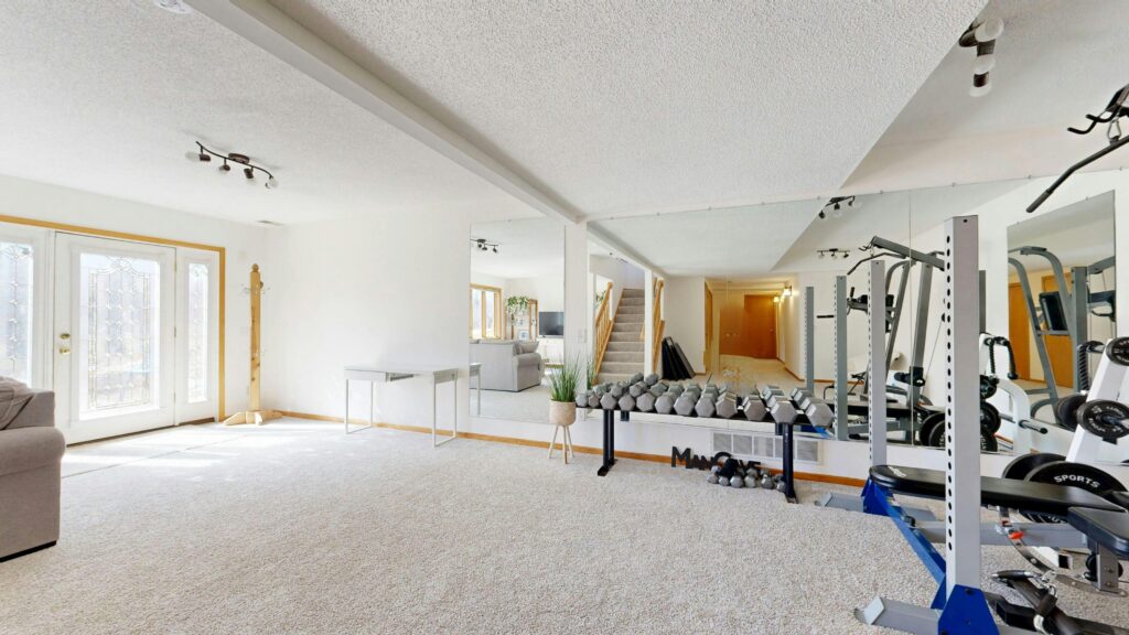 Bright home gym setup with weights, mirrors, and modern decor.