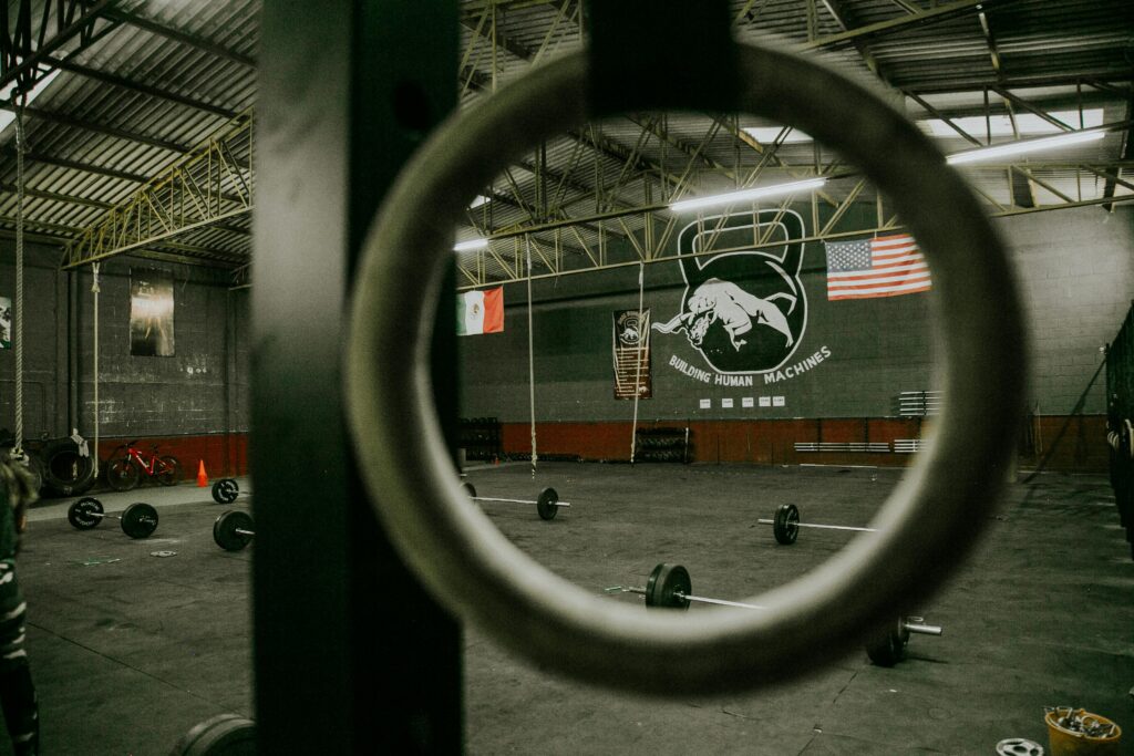 View of an empty gym with barbells and flags, ready for crossfit or weightlifting.