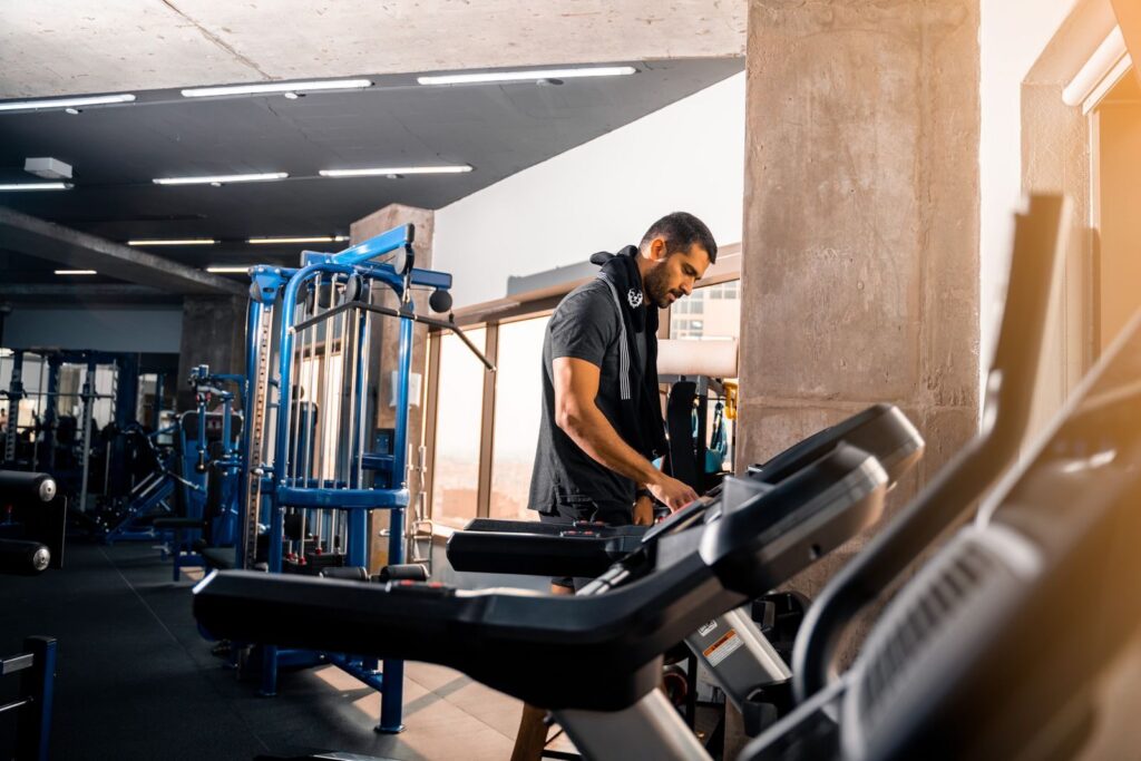 A man with short hair works out on a treadmill in a modern gym in Bahrain.