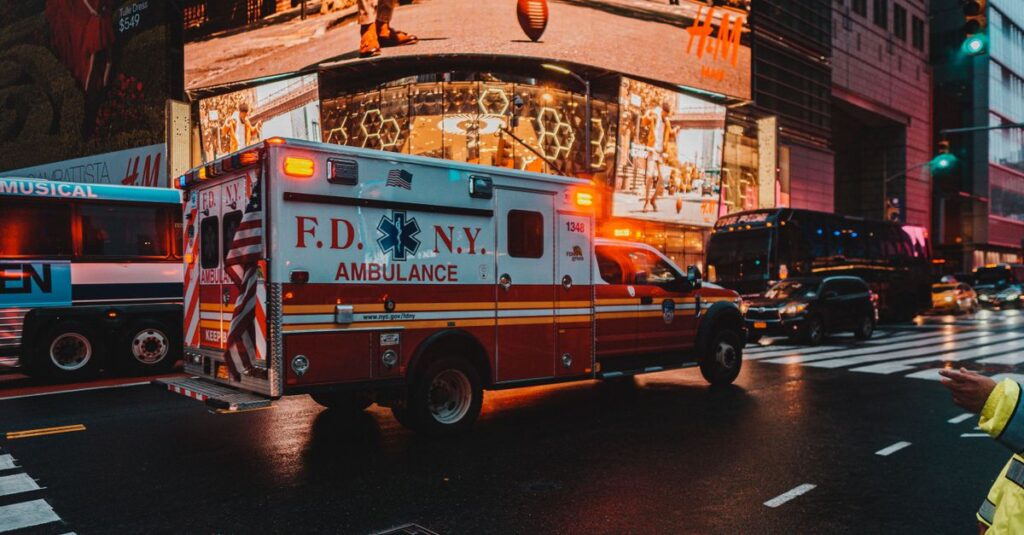 New York City ambulance on a bustling street at night, capturing the vibrant city lights and atmosphere.