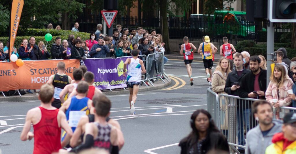 Runners competing in a marathon with spectators cheering along city streets.