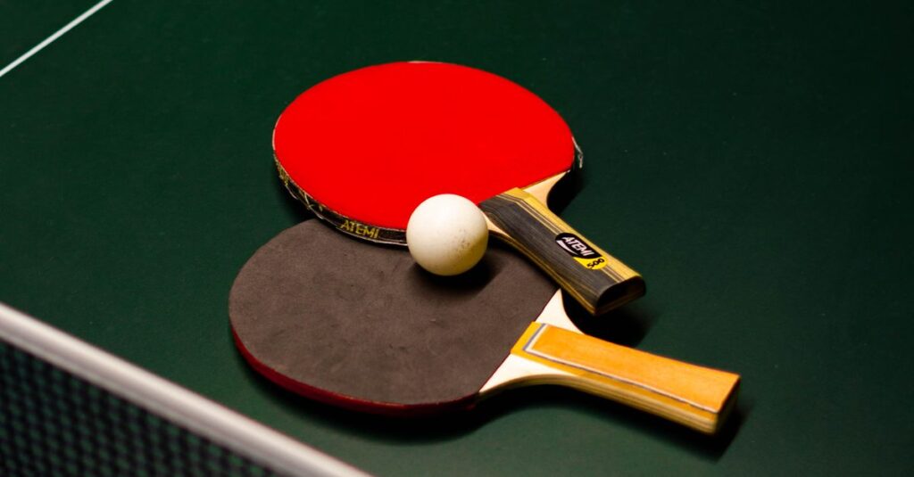 Table tennis paddles and ball on a green table. Ideal for sports themes.