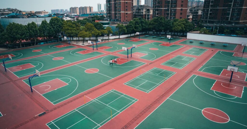 Aerial shot of multiple basketball courts in a residential area of Jiujiang, surrounded by skyscrapers.