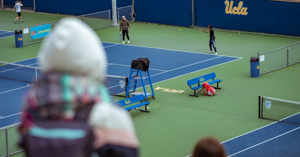 View of a tennis match at UCLA courts with spectators.