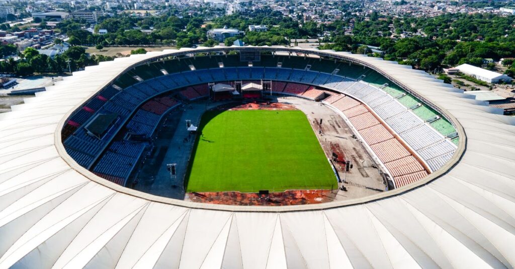 Aerial view of Benjamin Mkapa Stadium in Dar es Salaam, showing the vibrant green field and surrounding cityscape.
