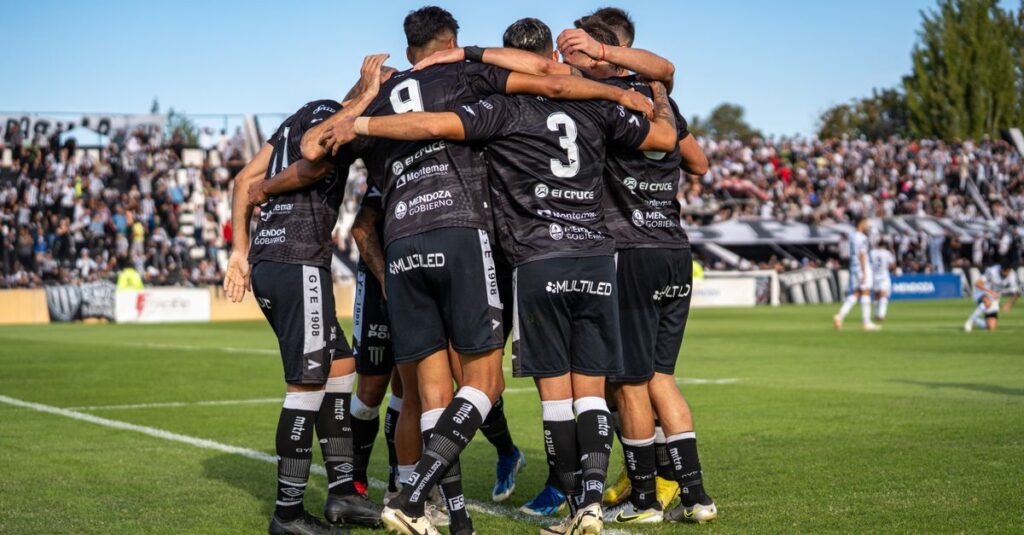 Soccer players celebrating a goal during a match in a vibrant stadium atmosphere.