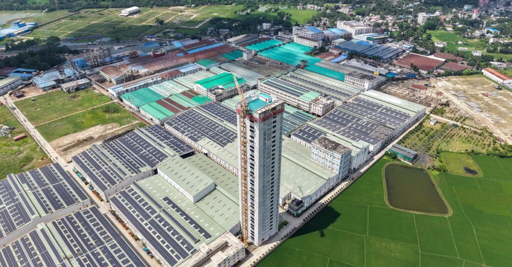 Aerial view of a large industrial factory complex and green fields.