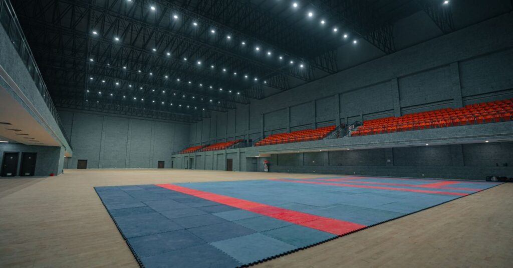 Large indoor sports venue in Surat, India, with ample seating and matted flooring.