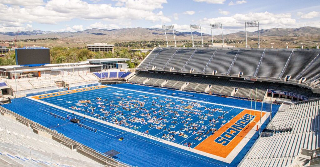 Aerial view of a yoga session taking place on the iconic blue turf of a stadium in Boise, Idaho.