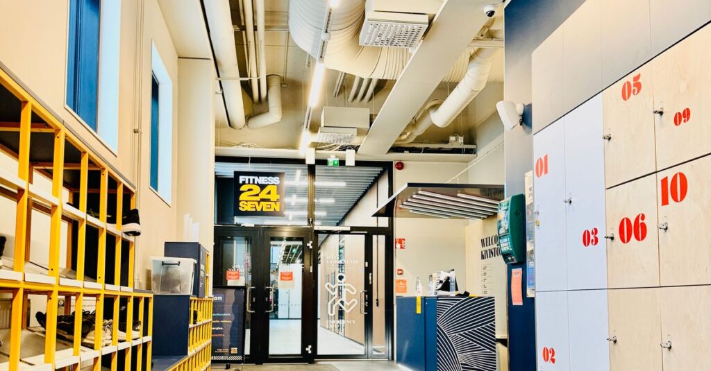 Bright and organized modern gym entrance with lockers, reception desk, and clean layout.