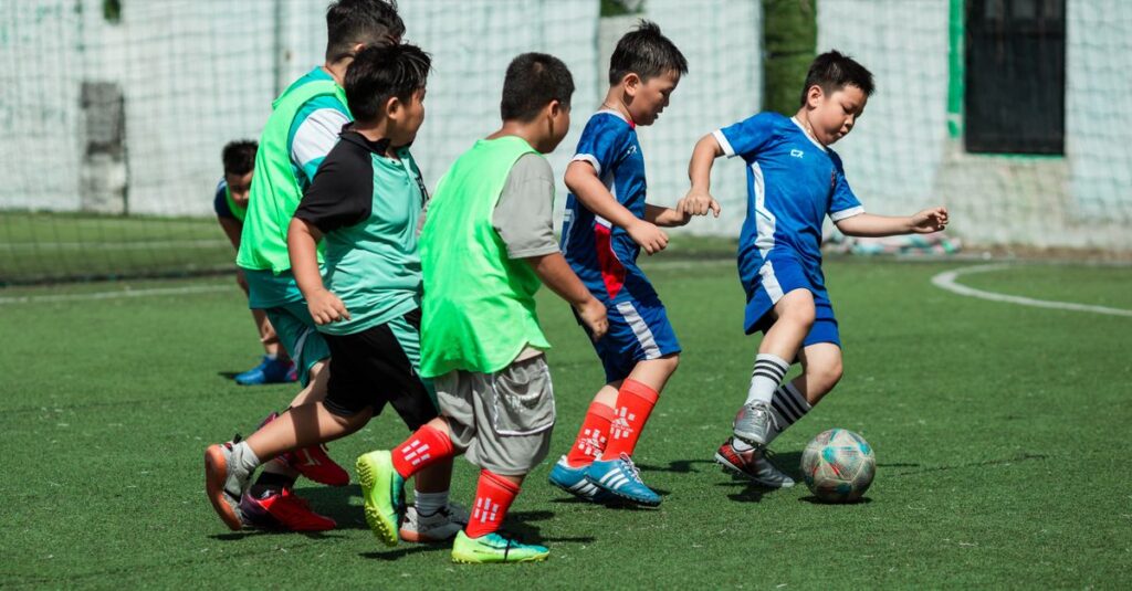 A group of boys energetically playing soccer outdoors on a sunny day in Vietnam.