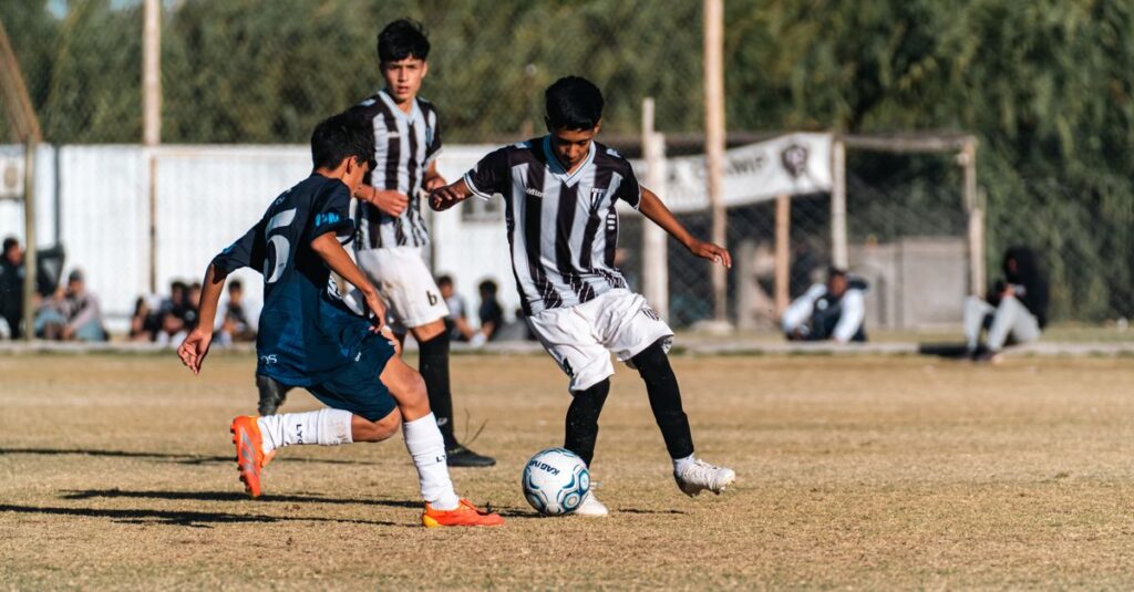 Boys playing soccer outdoors on a sunny day, showcasing youthful energy and teamwork.