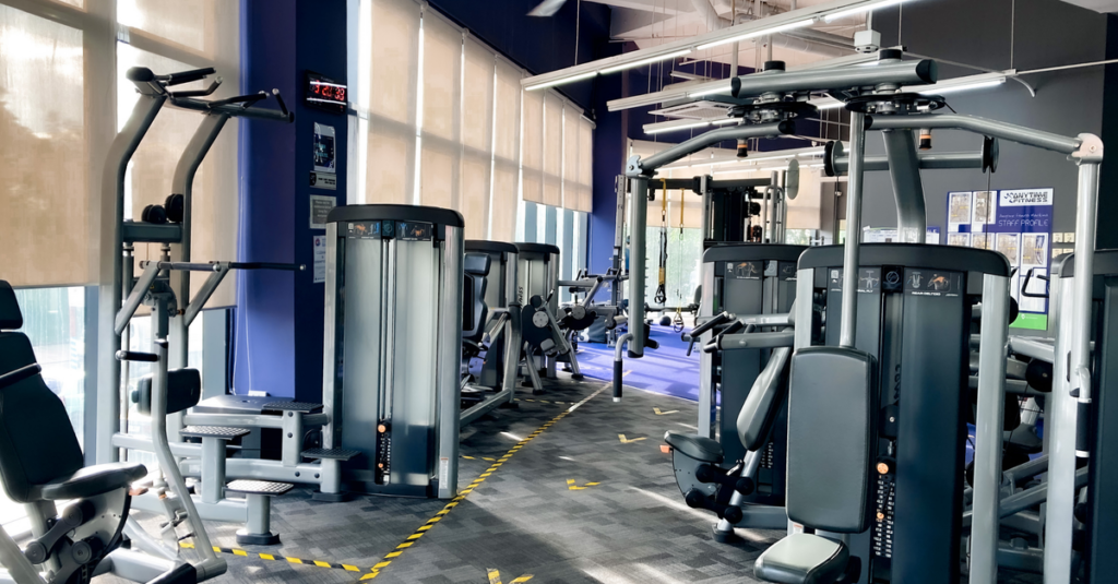A bright, spacious gym with various exercise machines creating a motivating fitness atmosphere.