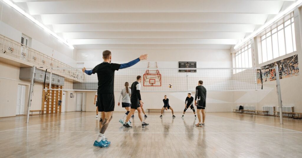 Energetic volleyball practice session with a mixed team indoors. Perfect for sports training themes.