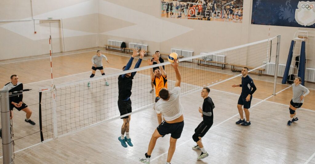 Exciting indoor volleyball game featuring diverse teams in action, jumping and playing.
