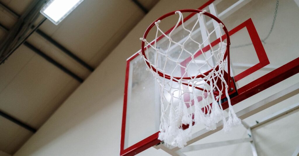 A basketball hoop captured from below in an indoor gym. Perfect for sports themes.