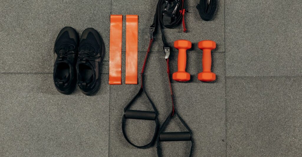 Flat lay of fitness gear including dumbbells, sneakers, and resistance bands for a home workout.