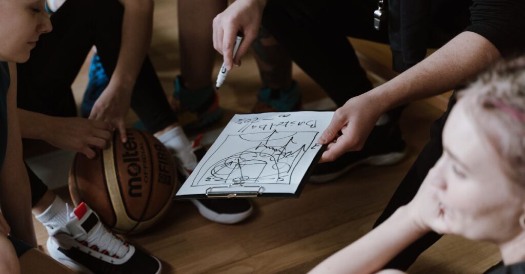 Close-up of a basketball team huddling with the coach discussing strategy indoors.