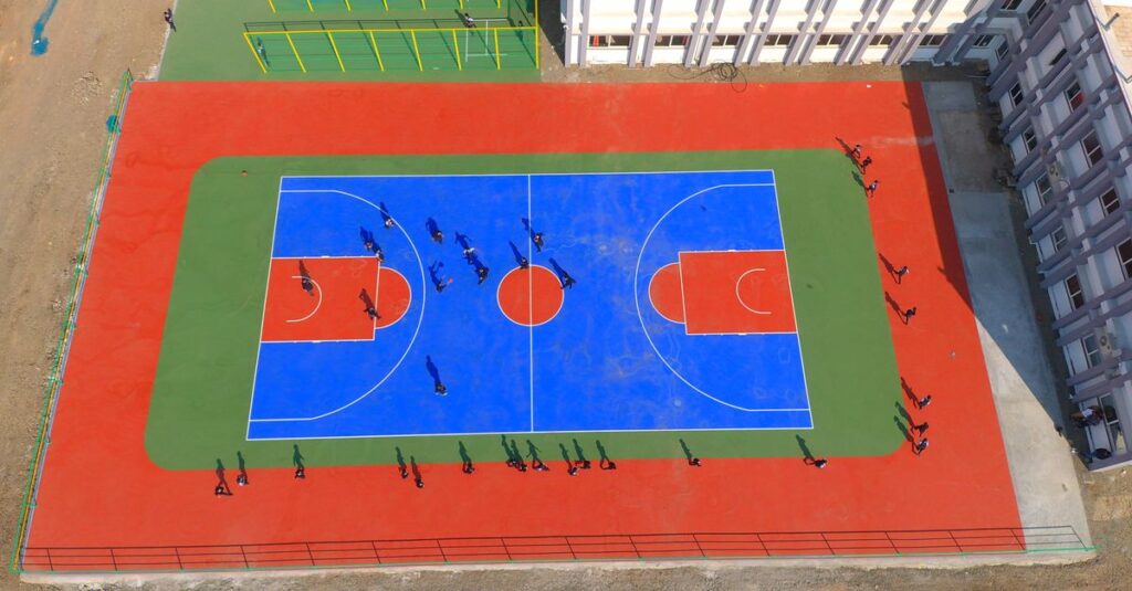 Drone image of a vibrant basketball court with players in Jamnagar, India.