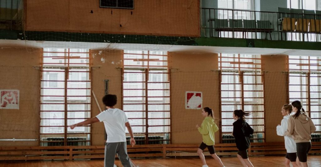 A group of children running in a gymnasium with wooden floors, focusing on motion and exercise.