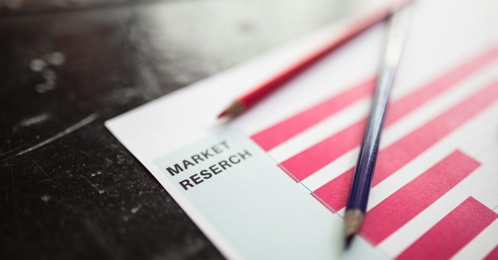 Close-up of market research paper with red graph bars and pencils, emphasizing business analysis.