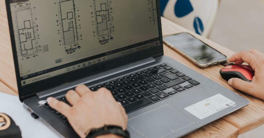 An architect working on building designs using a laptop outdoors, highlighting modern architecture.