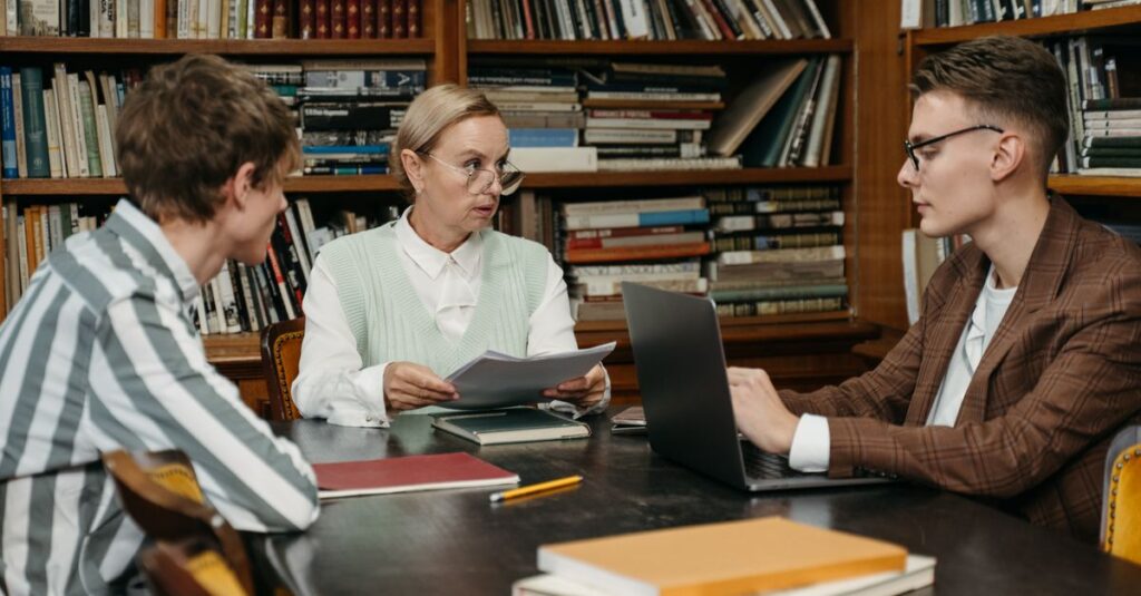 A focused group discussion among adults in a library with bookshelves.