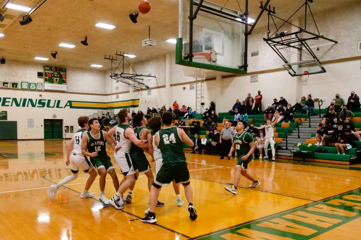 Energetic college basketball match in a gymnasium with spectators, capturing a pivotal moment near the hoop.