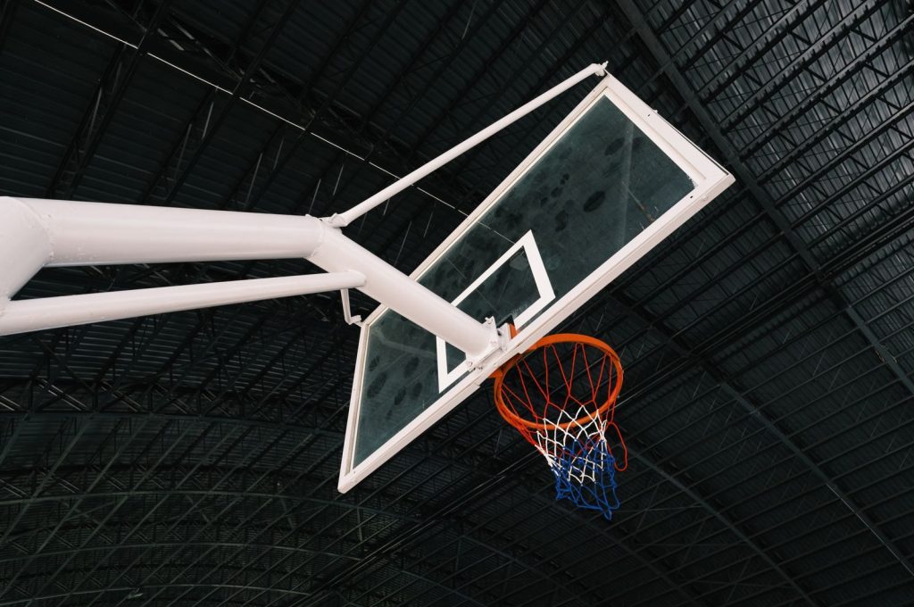 Close-up of an indoor basketball hoop and backboard in an empty sports hall.