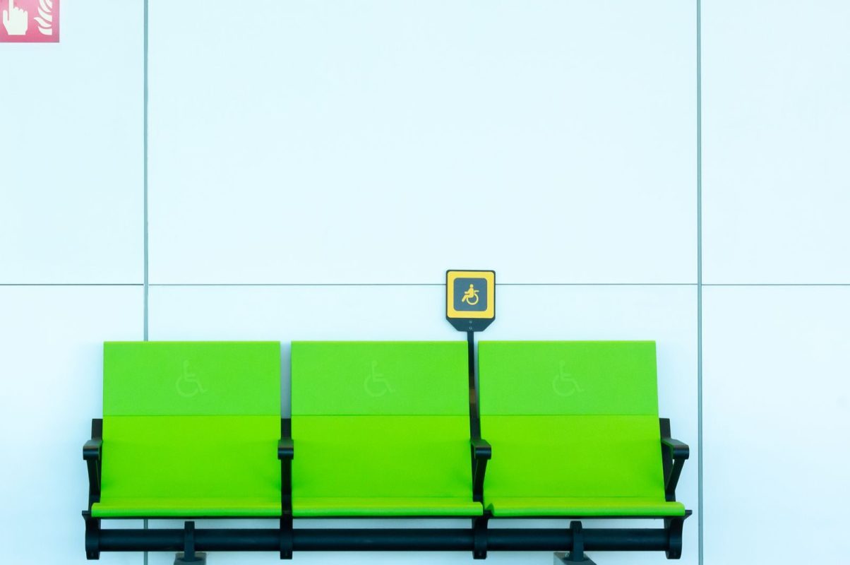 Vibrant green seats with handicap signs against a minimalist background.