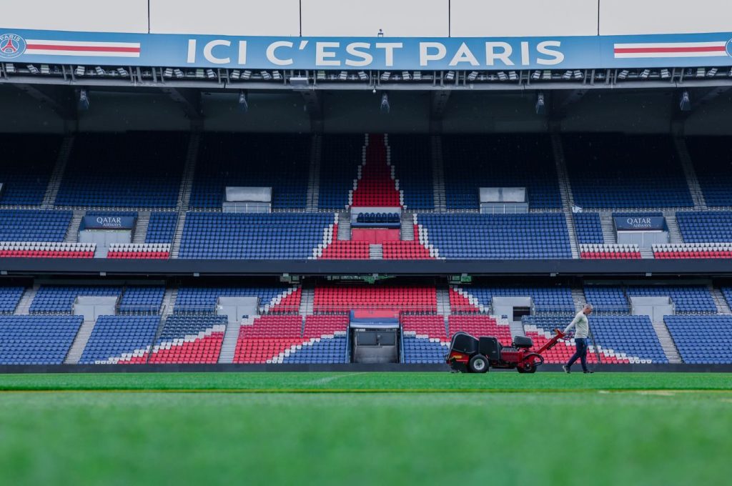 Gardener working on the field at Parc des Princes stadium, Paris. Vibrant and iconic sports venue.