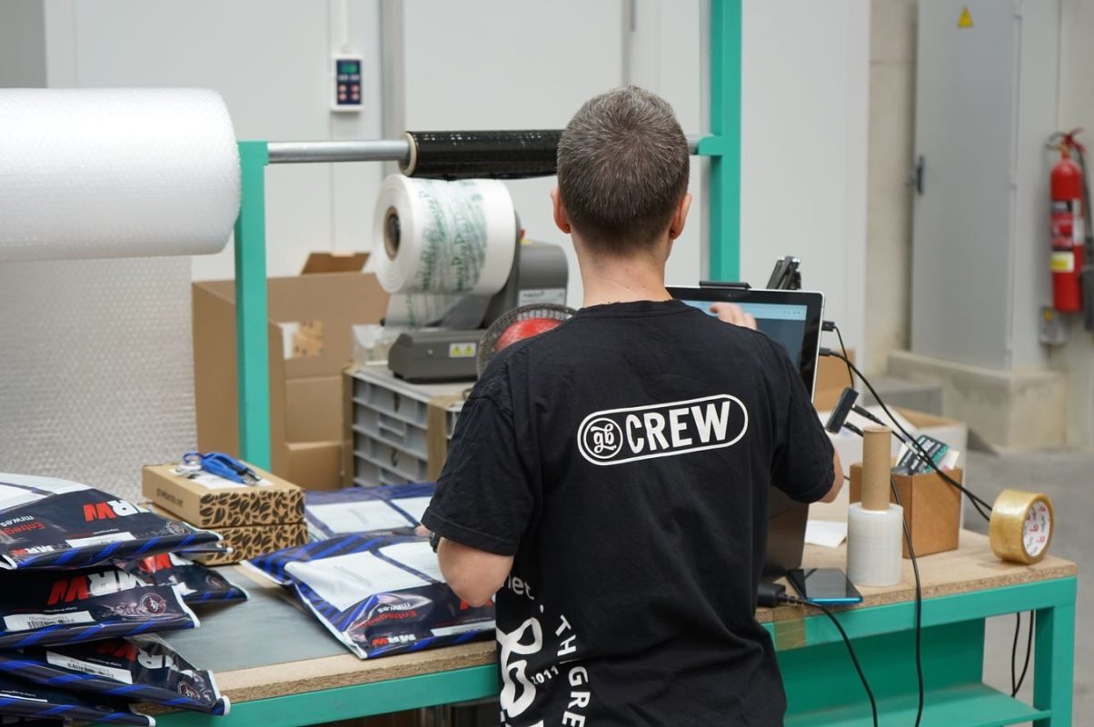 Warehouse worker using computer for inventory management at logistic center.