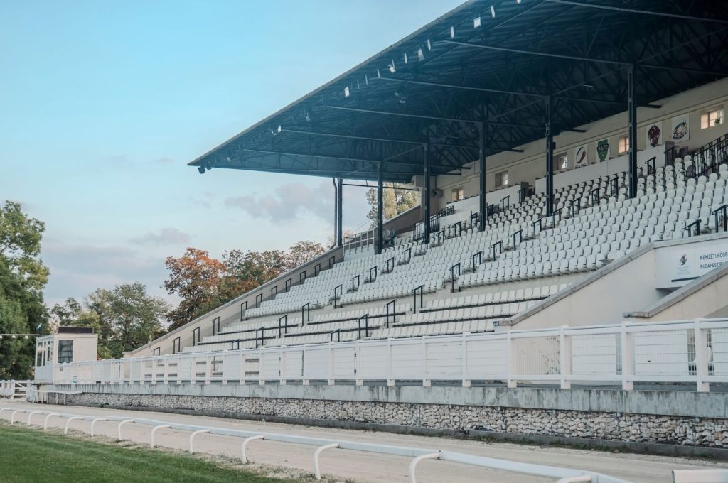 Empty grandstand seating in a sports stadium under a clear sky, ideal for sports events.