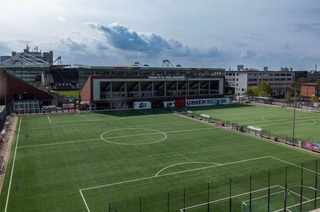 An aerial view of an empty soccer field and stadium in the city.