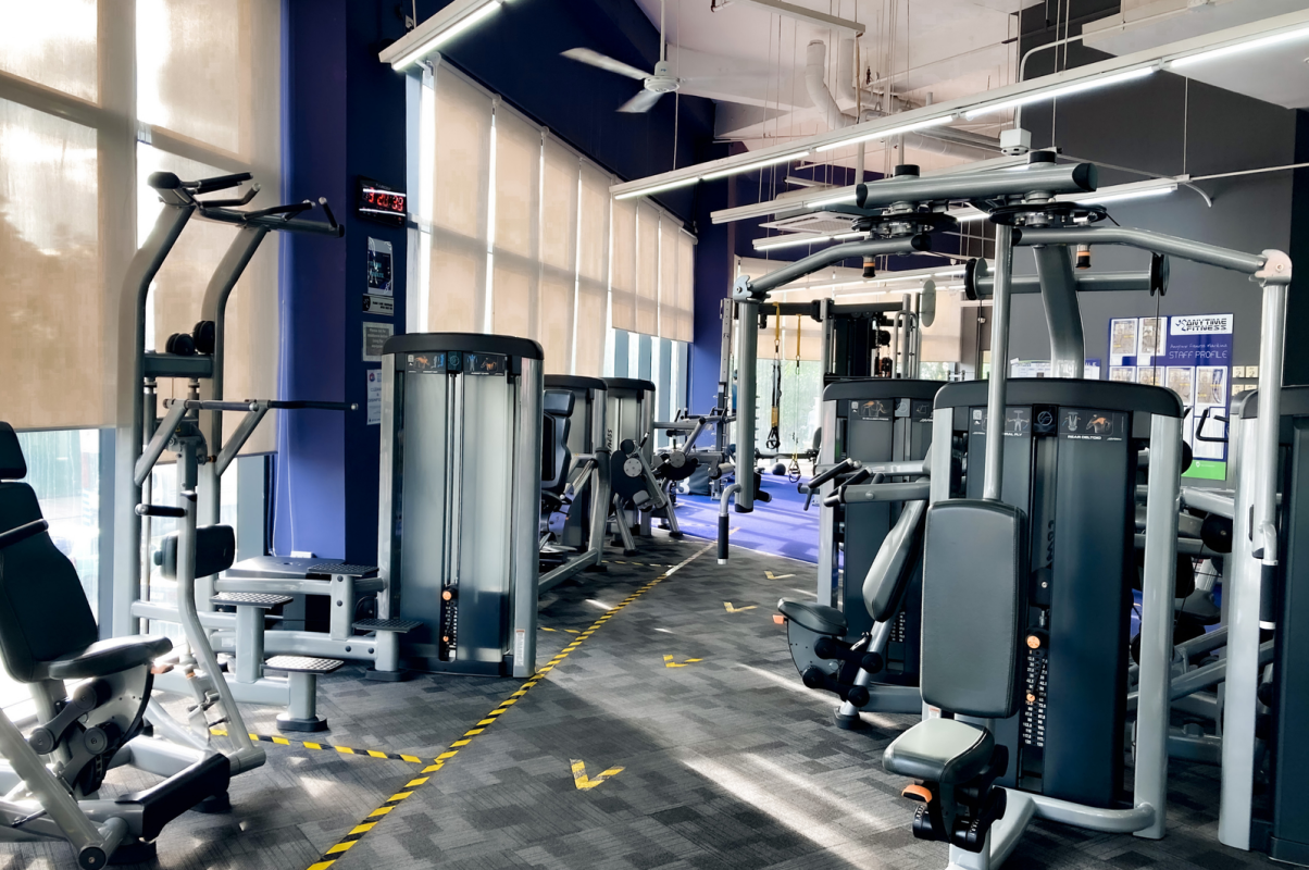 A bright, spacious gym with various exercise machines creating a motivating fitness atmosphere.