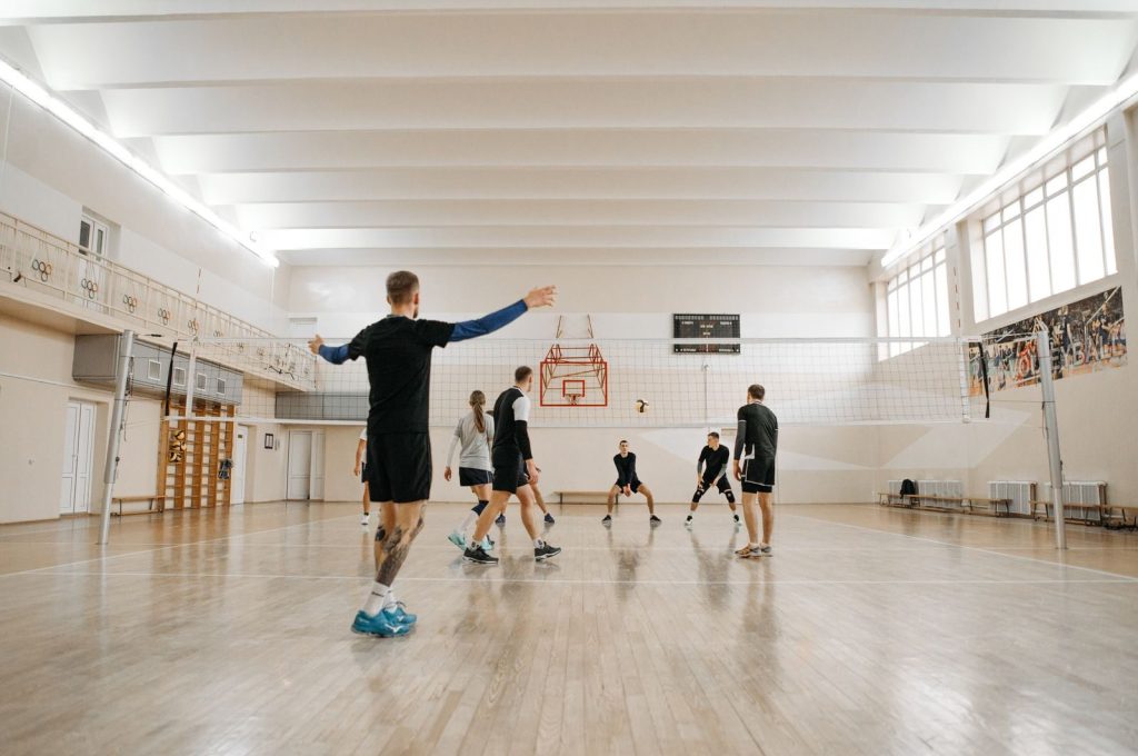 Energetic volleyball practice session with a mixed team indoors. Perfect for sports training themes.