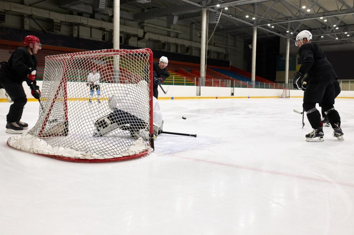 Competitive ice hockey players in action during a practice match inside an indoor rink.