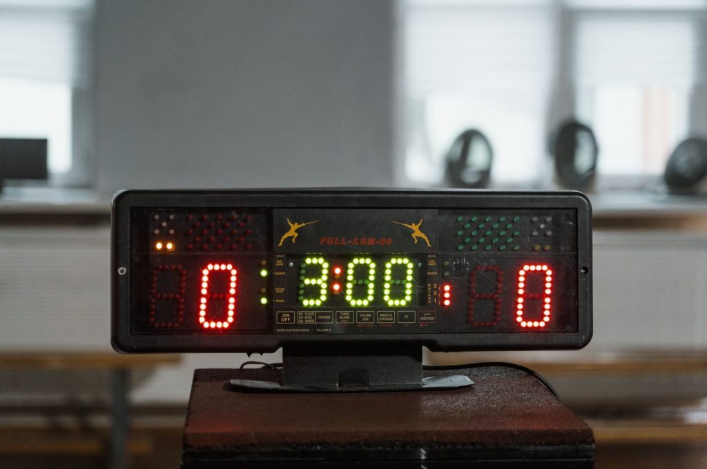Close-up of a digital fencing scoreboard indoors, displaying zero scores.
