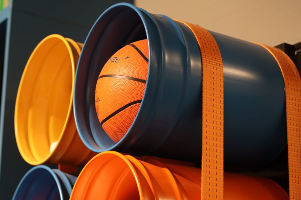 Brightly colored buckets with a basketball stored, perfect for sports enthusiasts.
