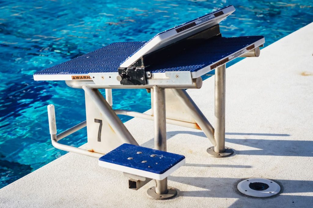 A close-up of a swimming pool starting block by the poolside, ready for competitors.