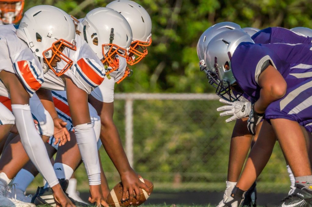 Players in full gear prepare for a football play in Columbia, MD.